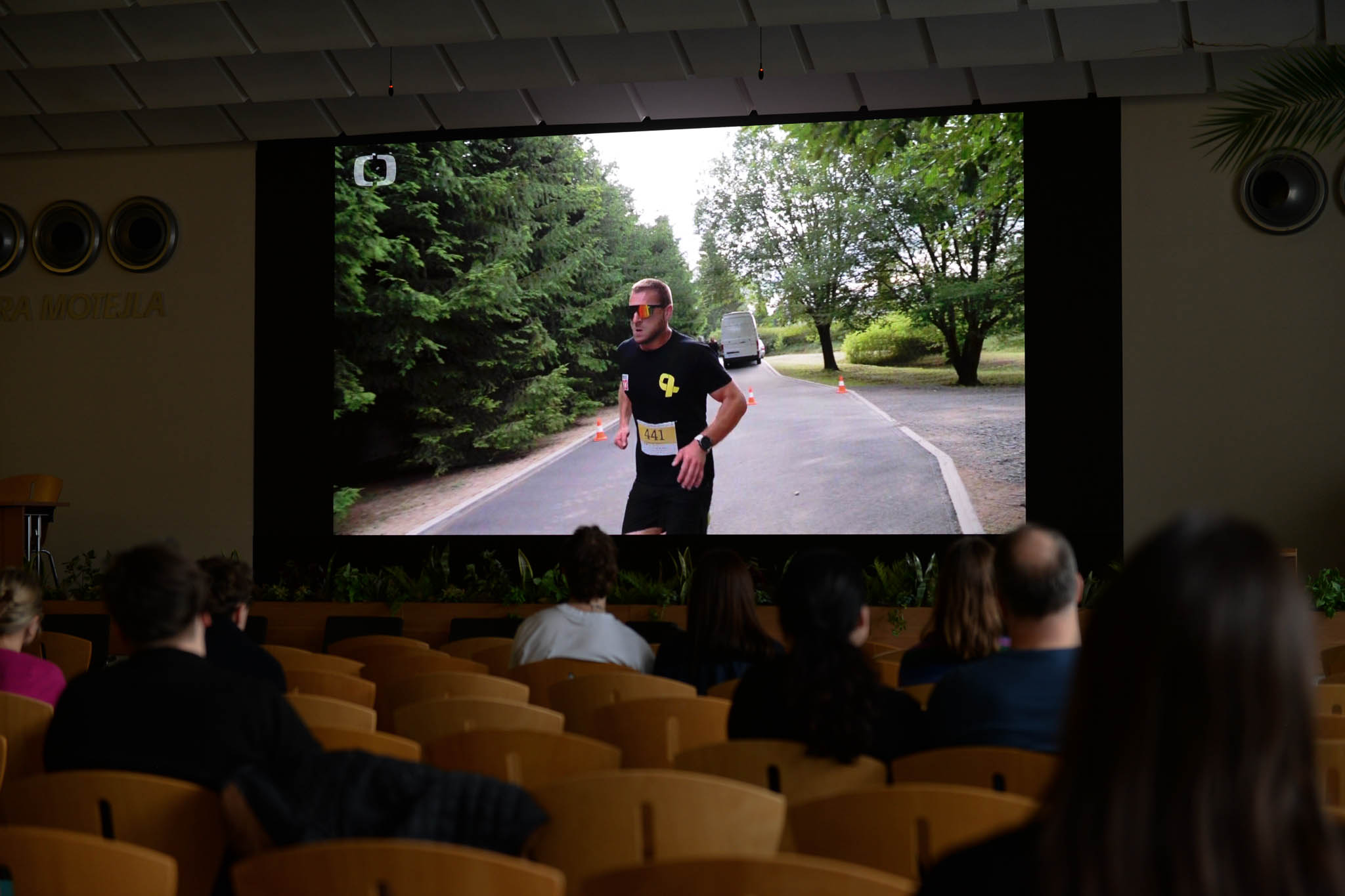 Na obrázku se promítá na velké ploše dokument. Zrovna v něm běží jeden z hrdinů závod Yellow Ribbon Run.