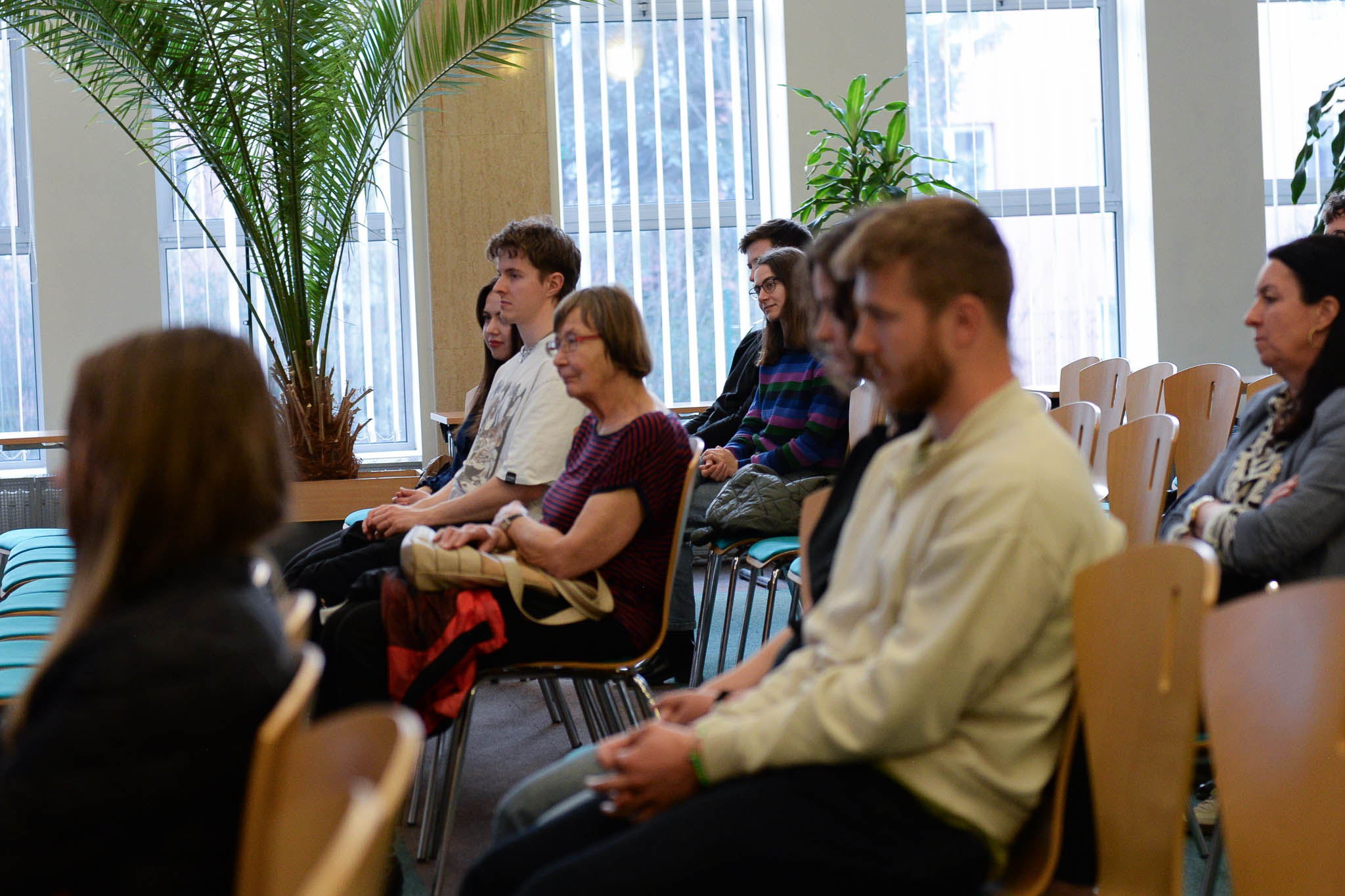 Na obrázku jsou diváci, kteří poslouchají diskusi.