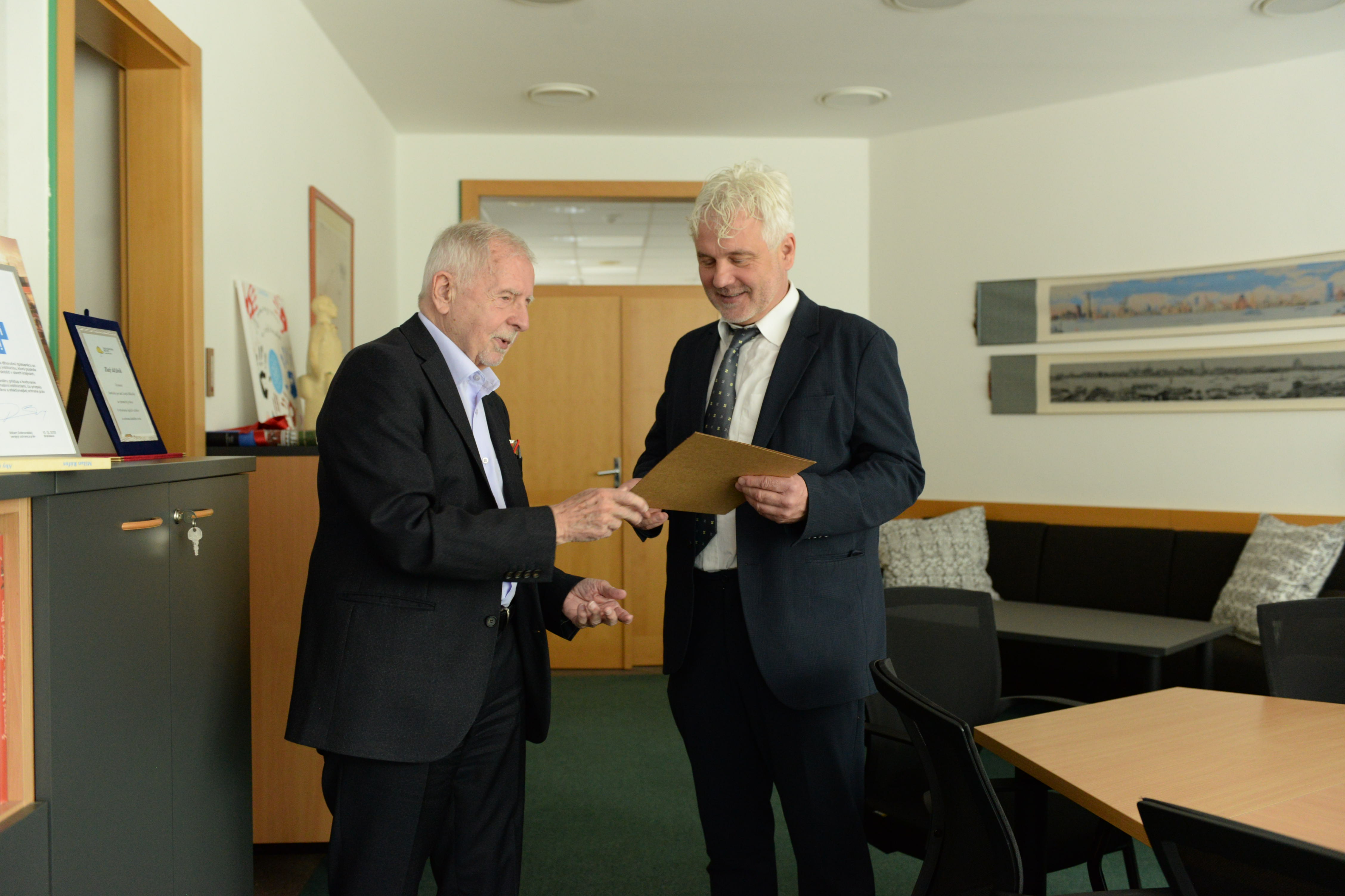 Ombudsman Křeček předává dar slovenskému komisaři pro děti.