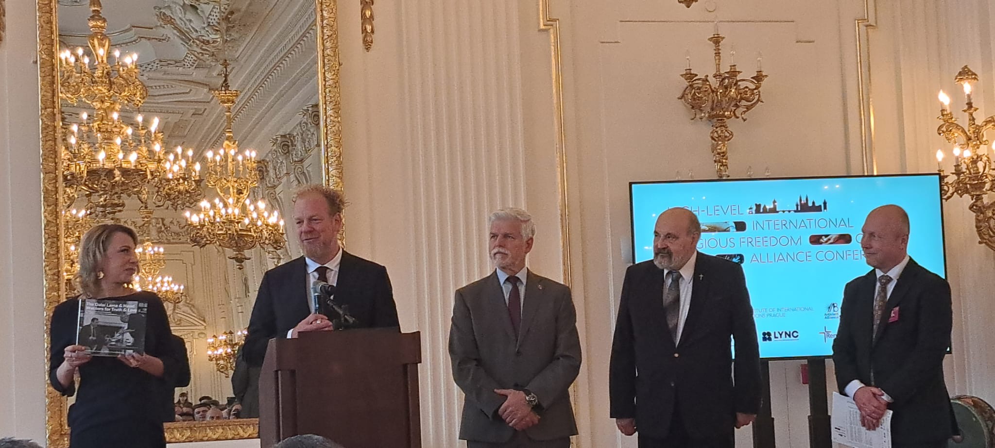 Na fotce jsou řečníci v čele s prezidentem Petrem Pavlem.