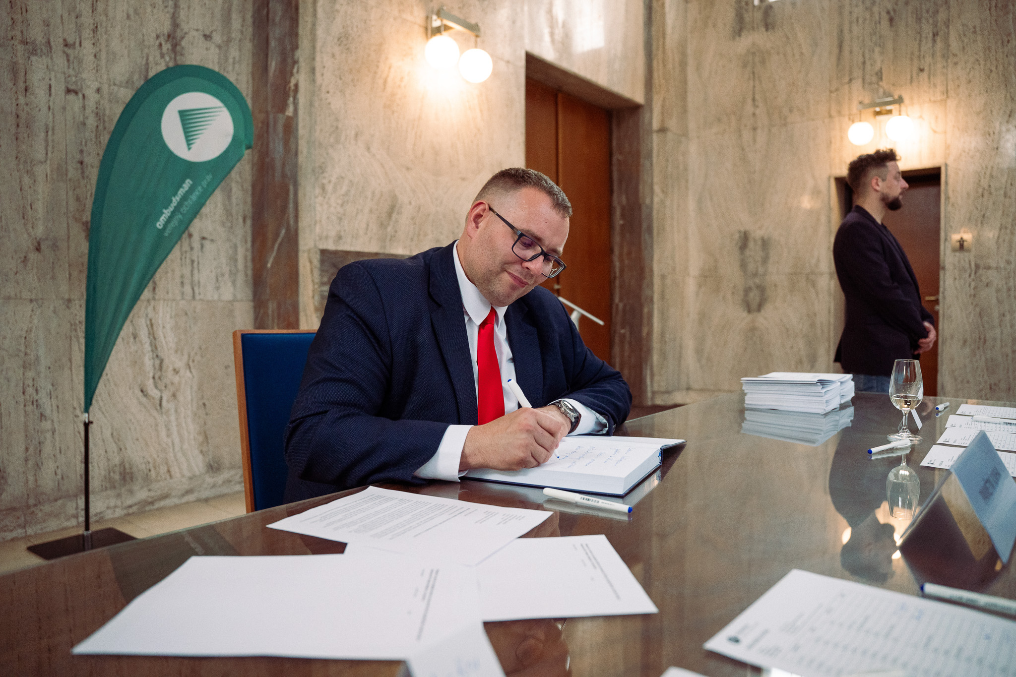 The Photo depicts slovak ombudsman Róbert Dobrovodský signing the ceremony book.